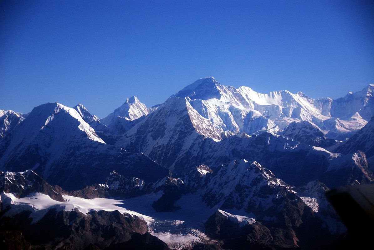 Kathmandu Mountain Flight 07-1 Cho Oyu With Tsoboje, Nangpai Gosum I, Takargo, And Gyachung Kang As the Kathmandu Mountain Flight continues flying over the Rolwaling Valley, the west and south faces of Cho Oyu (8210m), the sixth highest mountain in the world, comes into view. On the lower far left is Tsoboje (Chobutse, 6689m); the pointed peak to the left of Cho Oyu is Nangpai Gosum I (7351m, also called Cho Aui or Pasang Lhamu Chuli); the peak below Cho Oyu is Takargo (Dragker-Go, 6793m); and on the far right is Gyachung Kang (7952m).